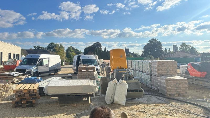 Baustelleneinrichtung mit Estrichpumpe, Dämmung und Material vor dem Gebäude